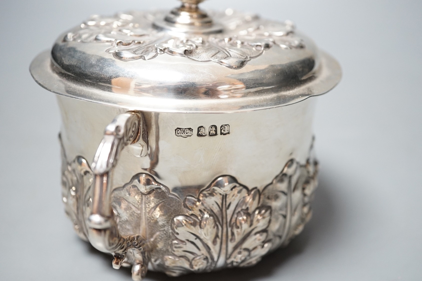 A George V embossed Brittania standard silver two handled presentation bowl and cover, Carrington & Co, London, 1916, diameter 18.6cm over handles, 18.5oz.